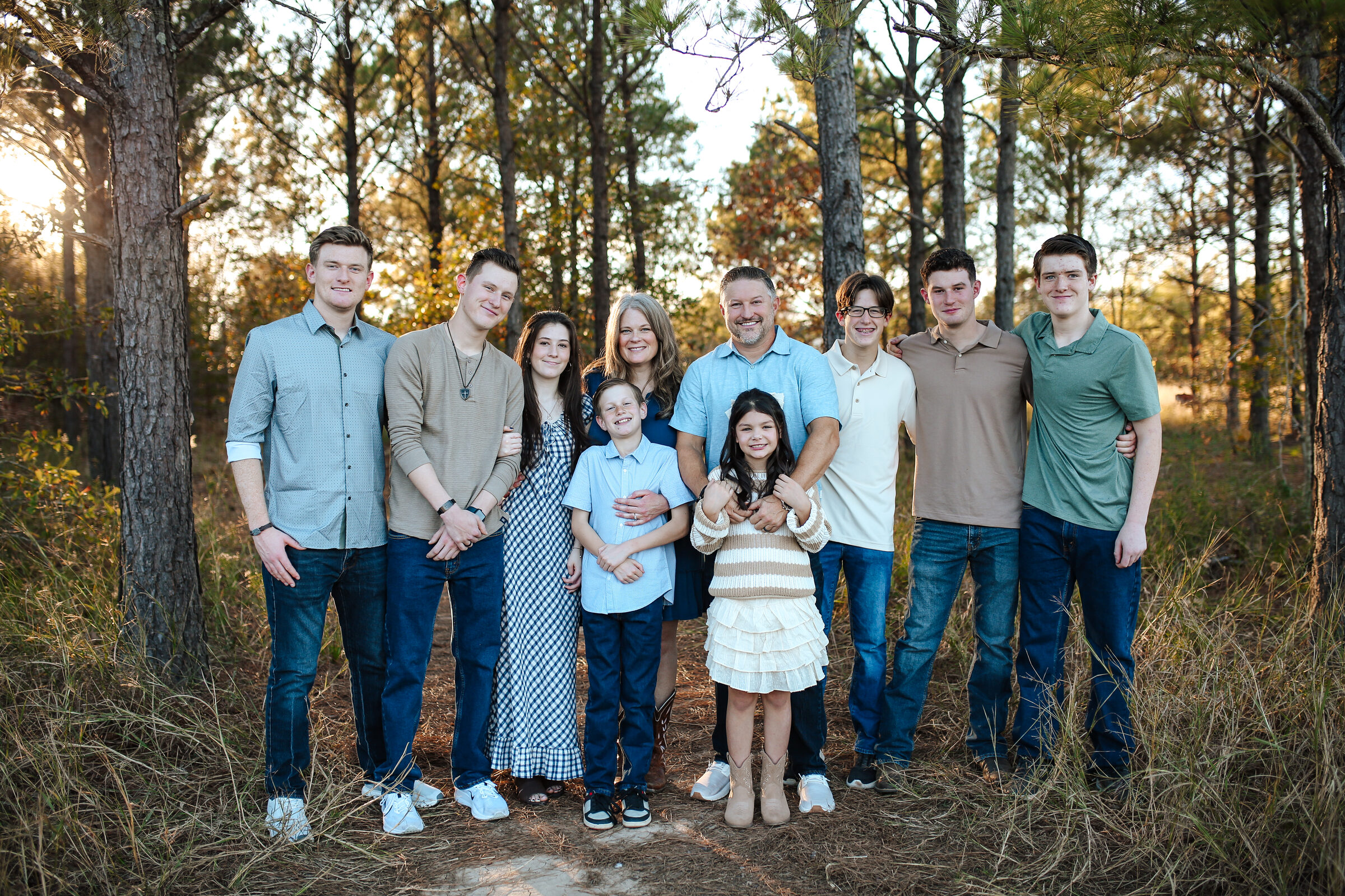 A large extended family standing together among the pines