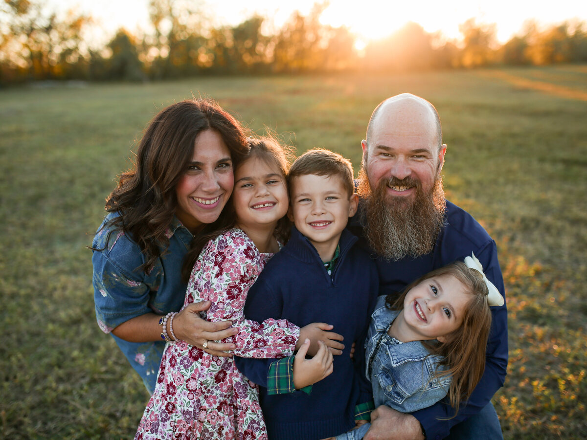 The Hunter family hugging close in a golden field