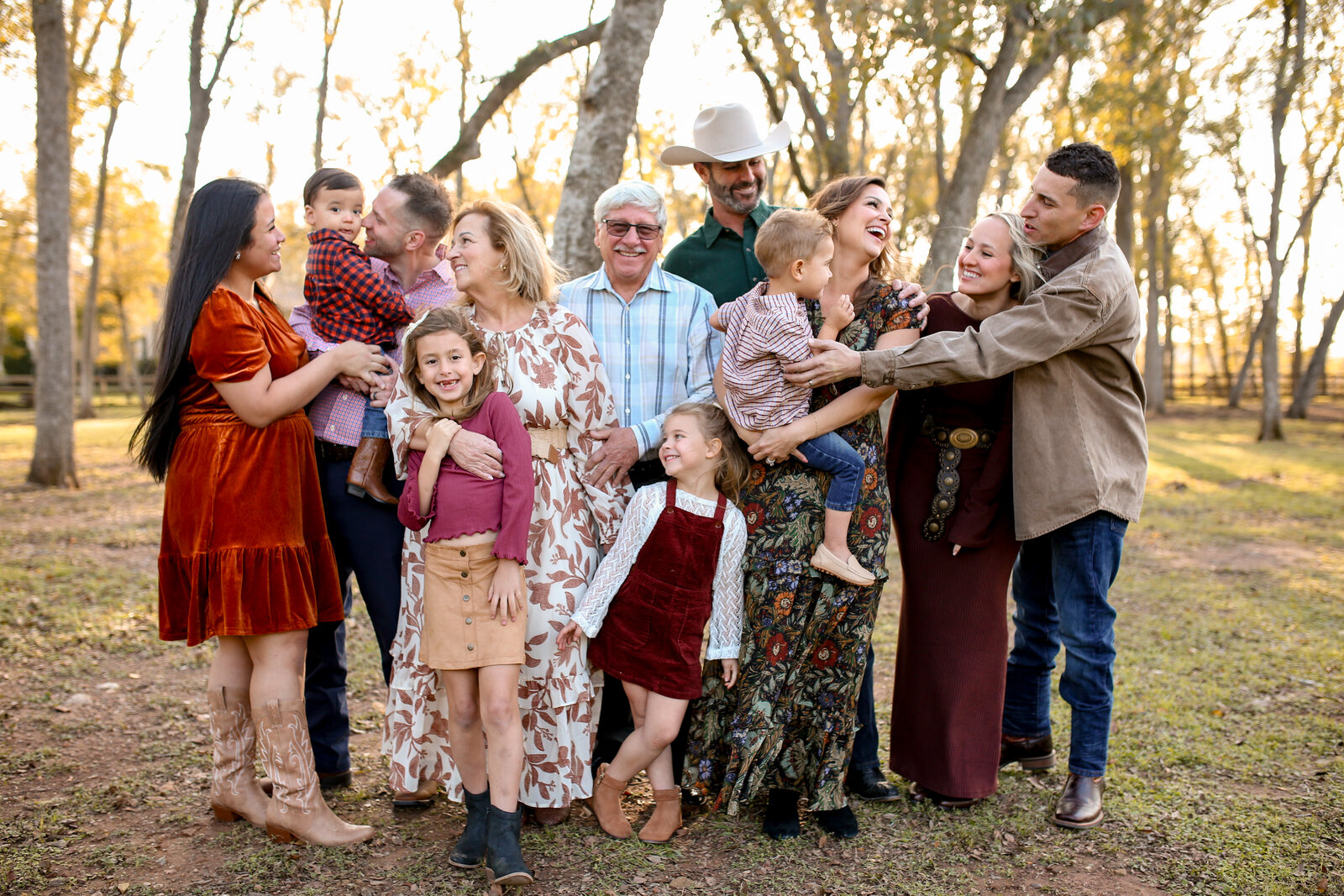 A big extended family laughing together under the oaks