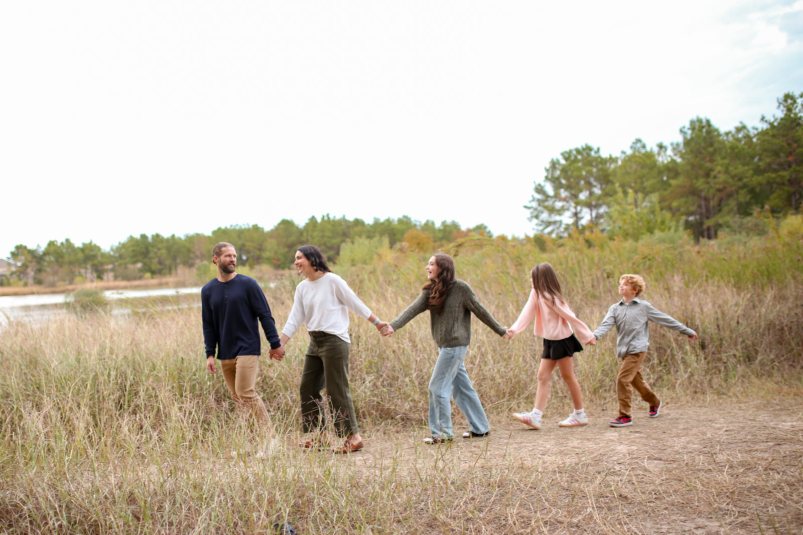 All the cousins holding hands on a walk through the field
