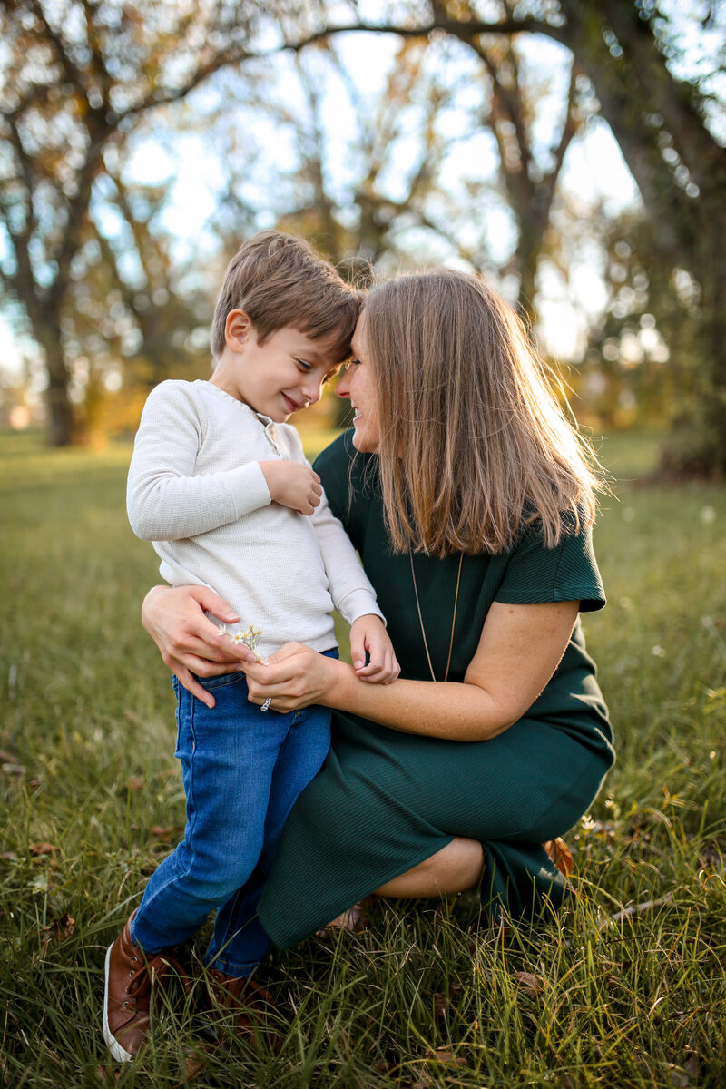 A mother and son touching foreheads in a golden meadow